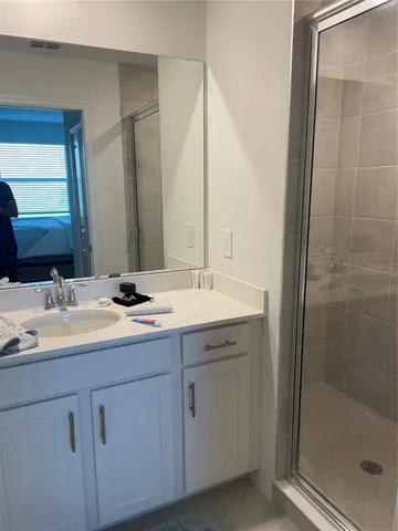 a bathroom with a double vanity sink mirror and shower