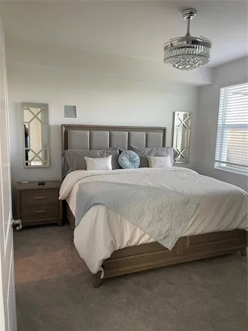 a bedroom with a bed and a chandelier