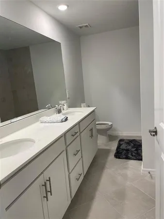 a bathroom with a double vanity sink and a toilet