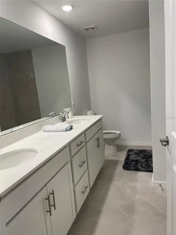 a bathroom with a double vanity sink and a toilet
