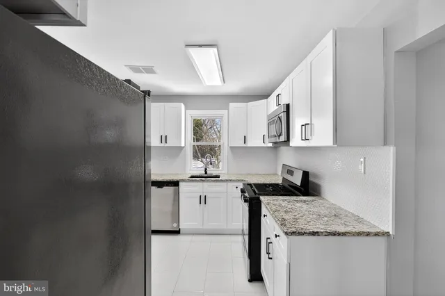 a kitchen with stainless steel appliances granite countertop a sink stove and cabinets