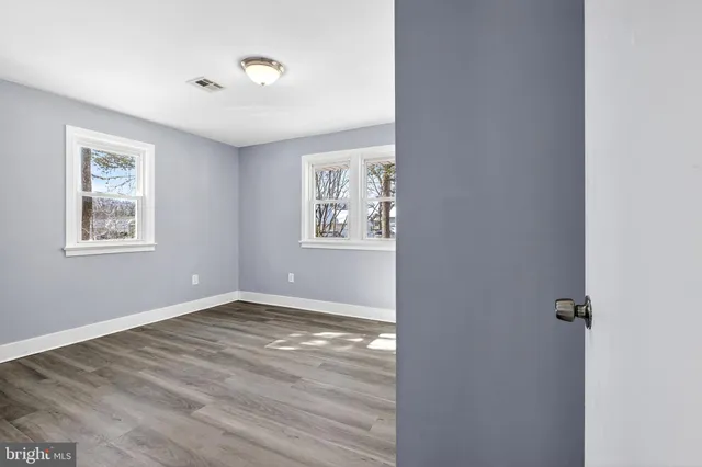 an empty room with windows and closet