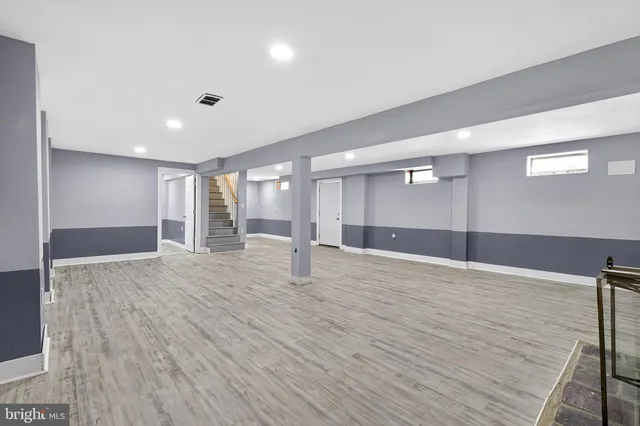 a view of an empty room with wooden floor and entryway