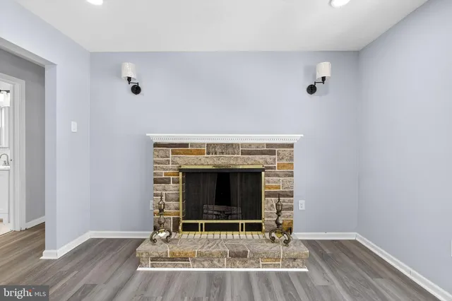 an empty room with wooden floor and fireplace