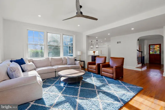 a kitchen with stainless steel appliances granite countertop a refrigerator a sink dishwasher a stove and white cabinets with wooden floor