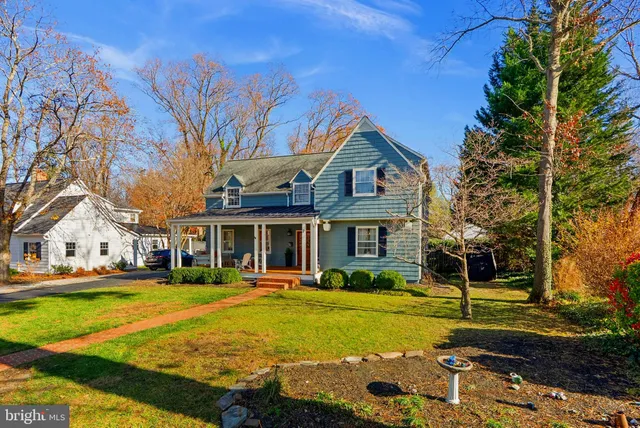 a front view of a house with garden and trees