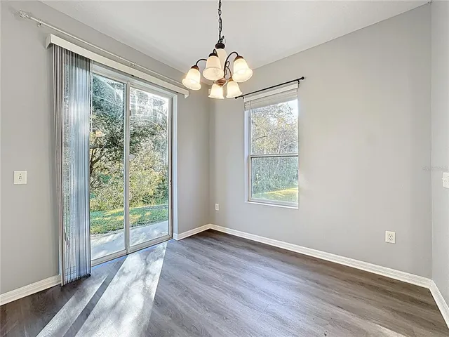 an empty room with wooden floor and ceiling fan