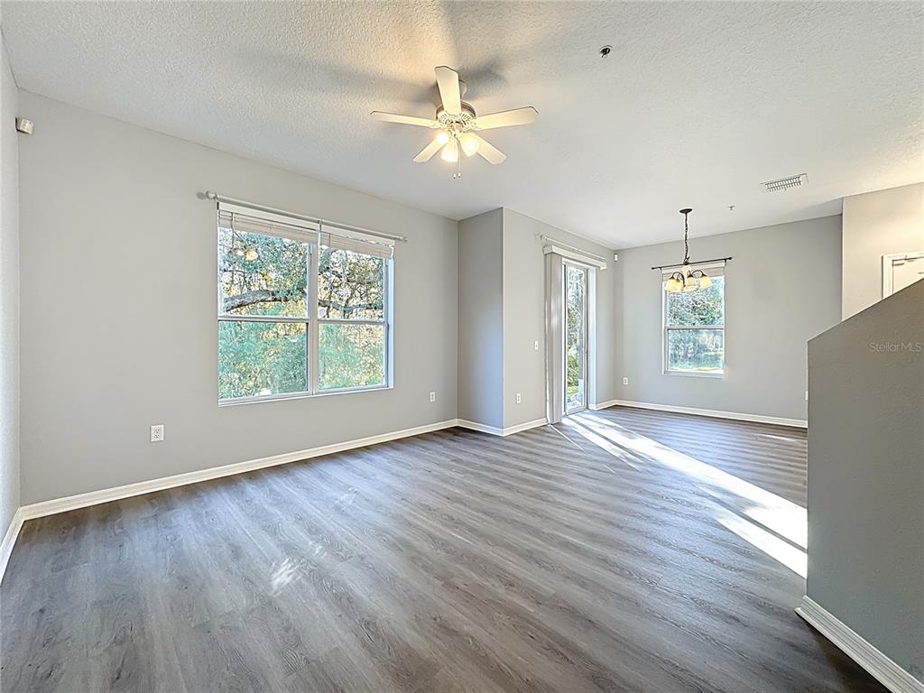 1500 Broken Oak Drive, Unit 25B Winter Garden, FL 34787 - Photo 23 of 62 an empty room with wooden floor chandelier fan and windows