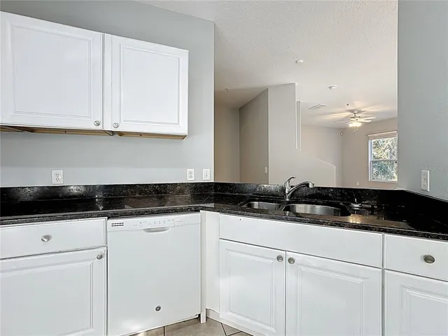 a kitchen with granite countertop a sink and cabinets