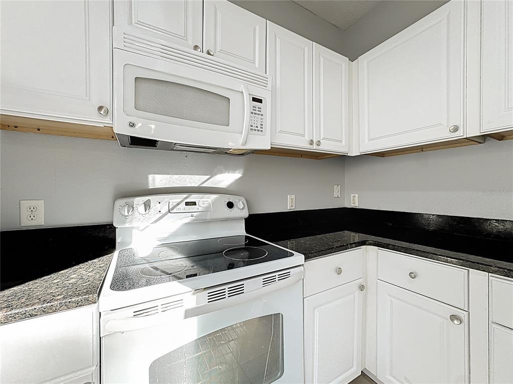 1500 Broken Oak Drive, Unit 25B Winter Garden, FL 34787 - Photo 26 of 62 a kitchen with white cabinets and white appliances