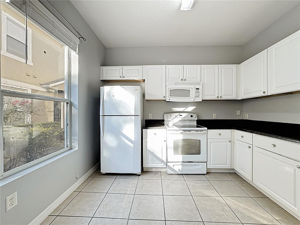 1500 Broken Oak Drive, Unit 25B Winter Garden, FL 34787 - Photo 28 of 62 a kitchen with cabinets and a refrigerator