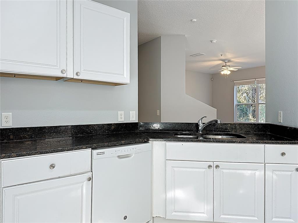 1500 Broken Oak Drive, Unit 25B Winter Garden, FL 34787 - Photo 30 of 62 a kitchen with granite countertop a sink and cabinets