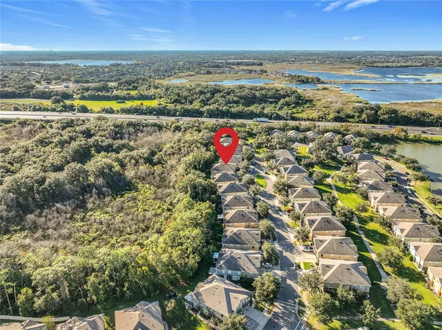 an aerial view of residential houses with outdoor space and trees