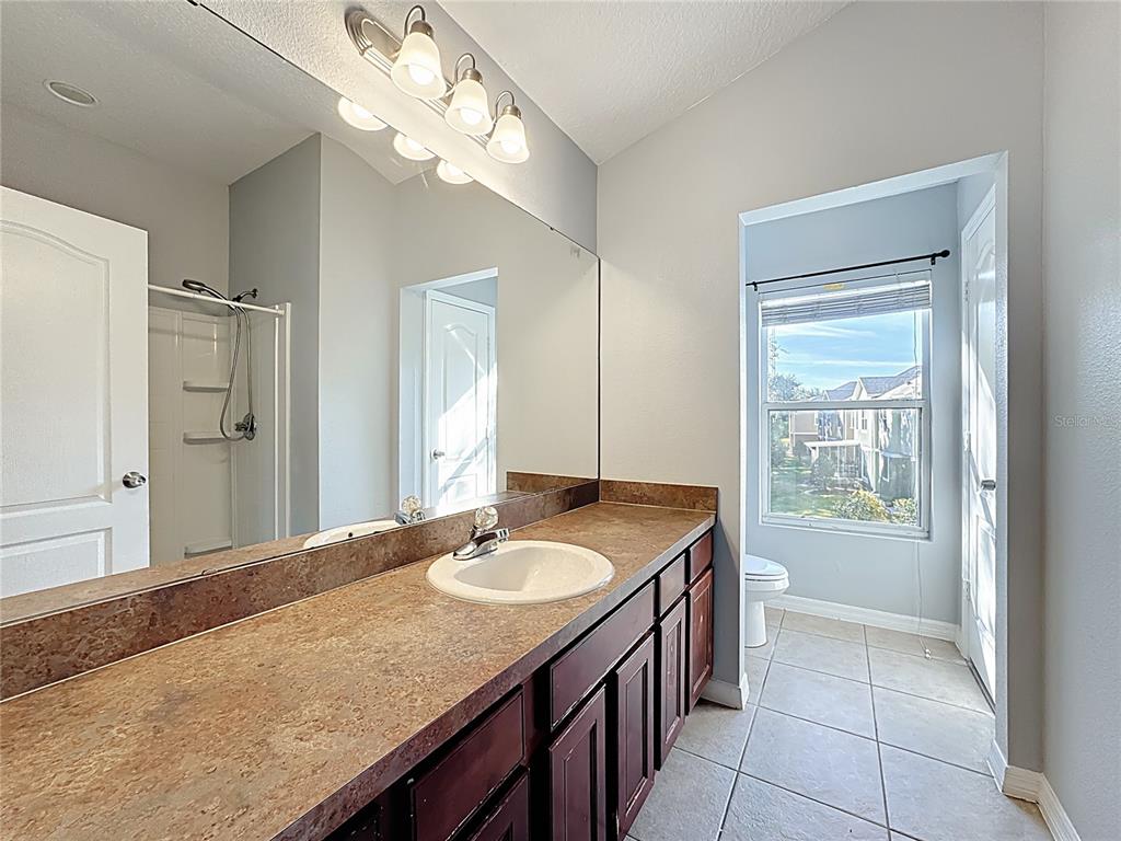 1500 Broken Oak Drive, Unit 25B Winter Garden, FL 34787 - Photo 50 of 62 a bathroom with a granite countertop sink a light fixture and a mirror
