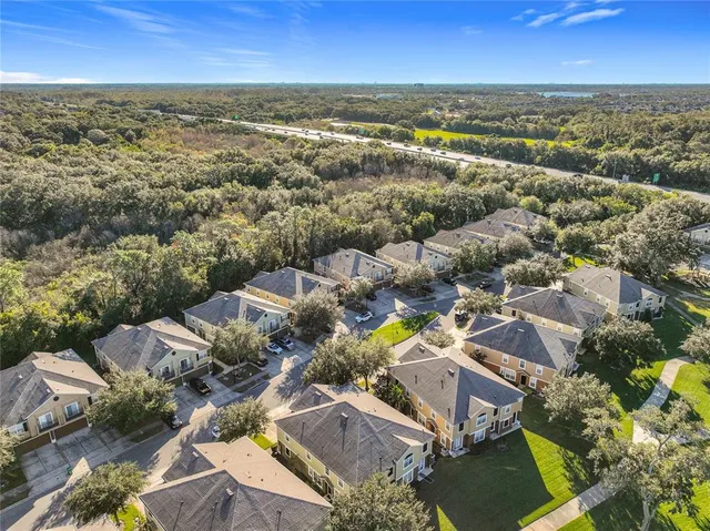an aerial view of residential houses with outdoor space and ocean view