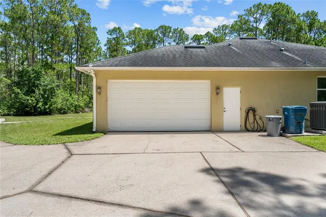 a view of a house with a yard and potted plants