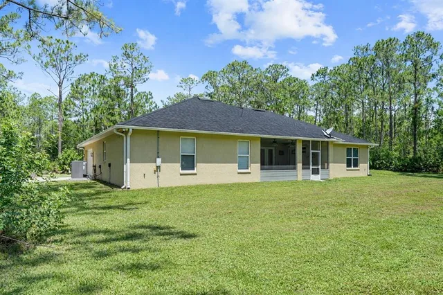 a front view of a house with a yard and trees