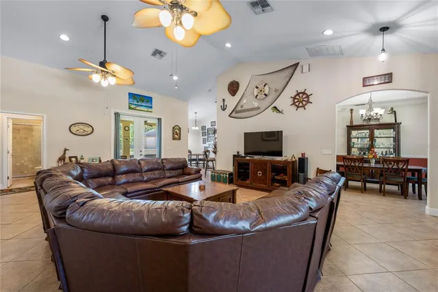 a living room with furniture a chandelier and a flat screen tv