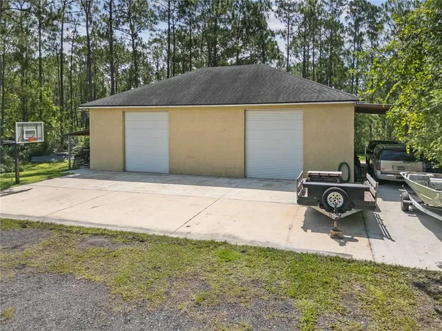 an aerial view of residential house with outdoor space and trees all around