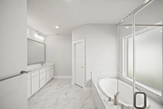 a bathroom with a tub sink and mirror