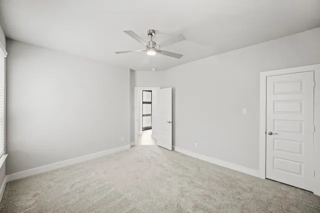an empty room with closet and fan