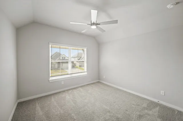 an empty room with a window and a ceiling fan