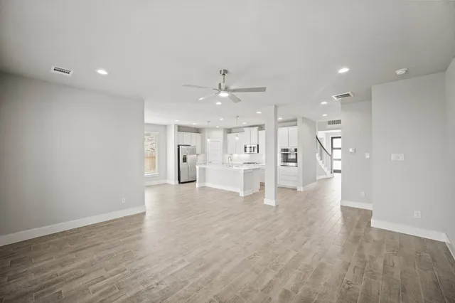 a view of an empty room and kitchen view