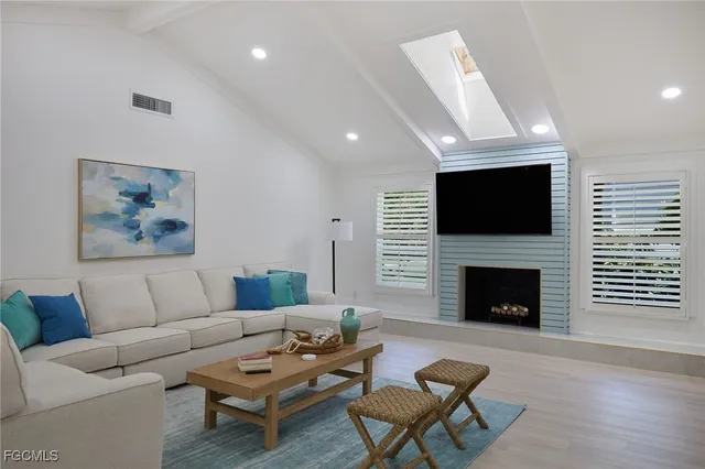a living room with furniture a fireplace and a flat screen tv