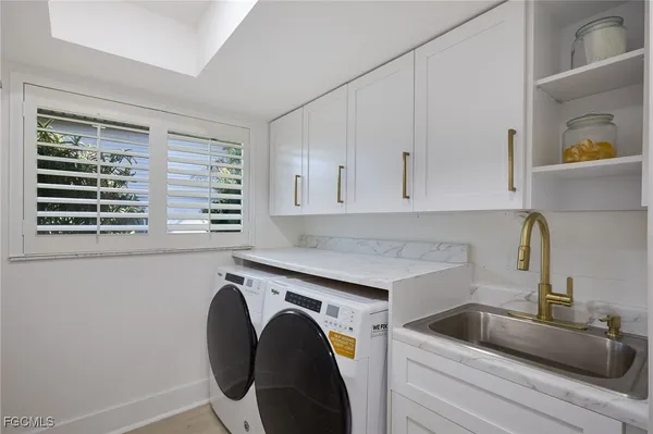 a utility room with sink dryer and washer
