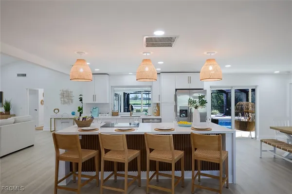 a dining room with stainless steel appliances a dining table and chairs