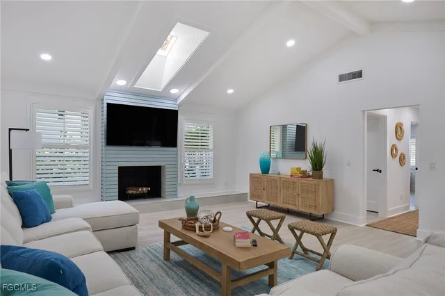 a living room with furniture a flat screen tv and a fireplace