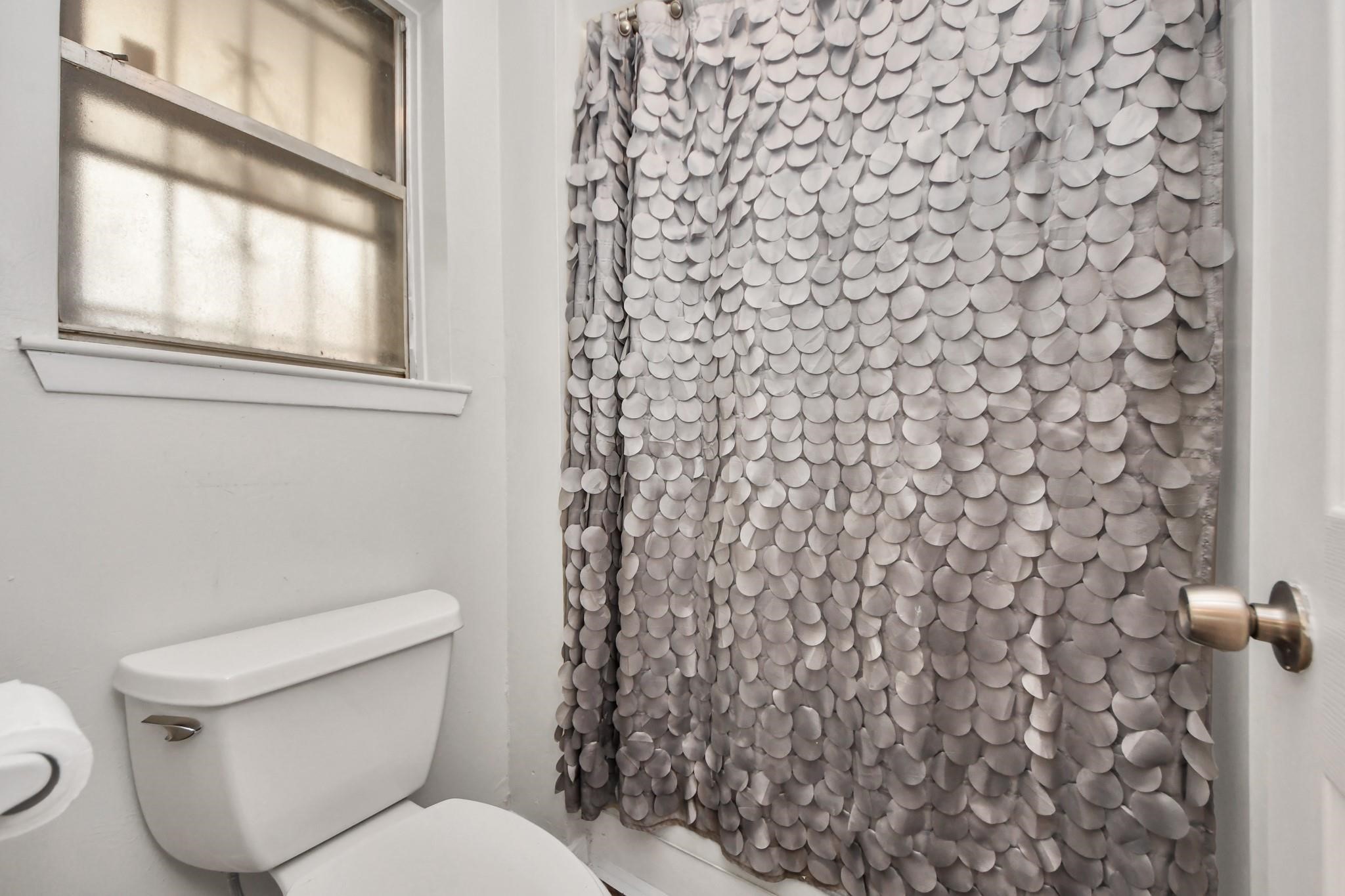 1415 Parry-Sound Pasadena, TX 77504 - Photo 19 of 34 a white toilet sitting next to a shower curtain