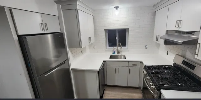 a kitchen with stainless steel appliances a refrigerator sink and stove