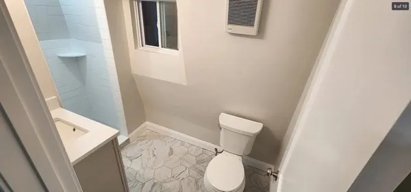 a white toilet sitting next to a shower