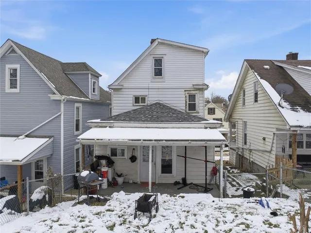 a view of a white house with large windows next to a road