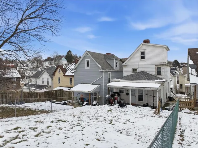 a view of a white house with large windows and a small yard