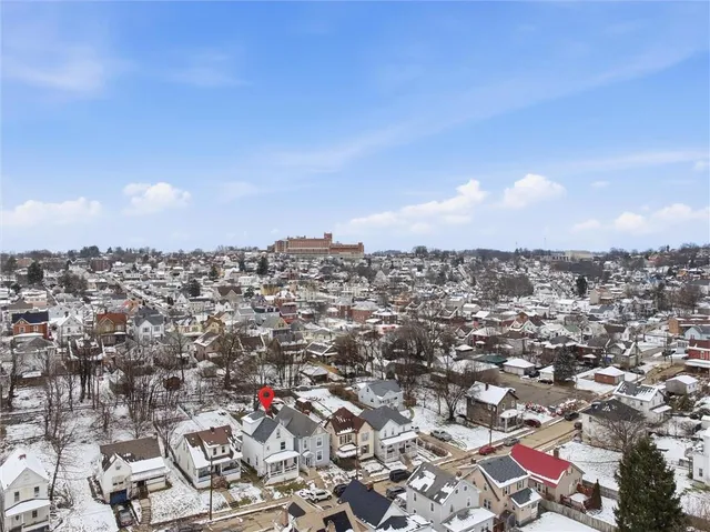 a front view of a house with a yard covered in snow