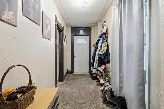 a living room with furniture a flat screen tv and a refrigerator