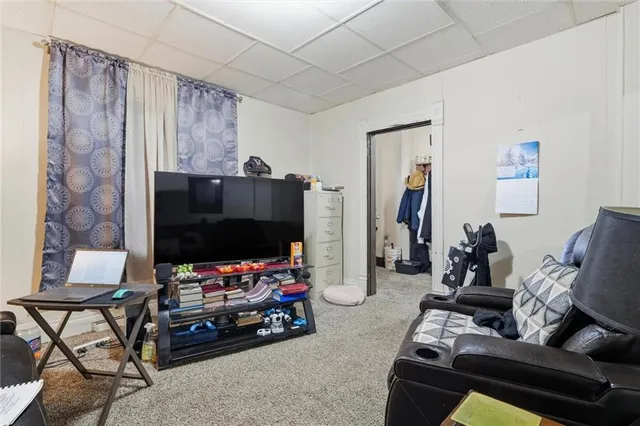 a living room with furniture a flat screen tv and a window