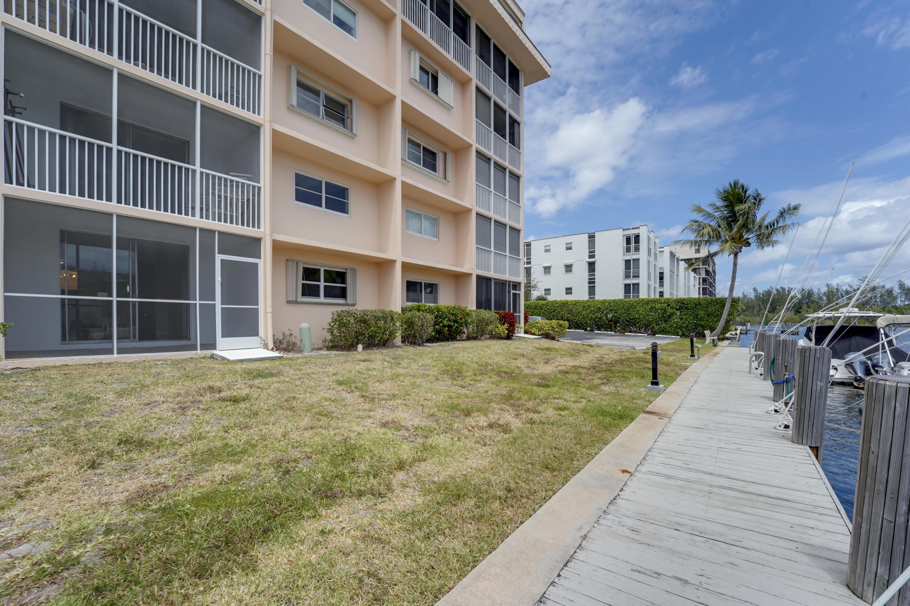 750 Northeast Spanish River Boulevard, Unit 102 Boca Raton, FL 33431 - Photo 37 of 42 a front view of a building with a yard