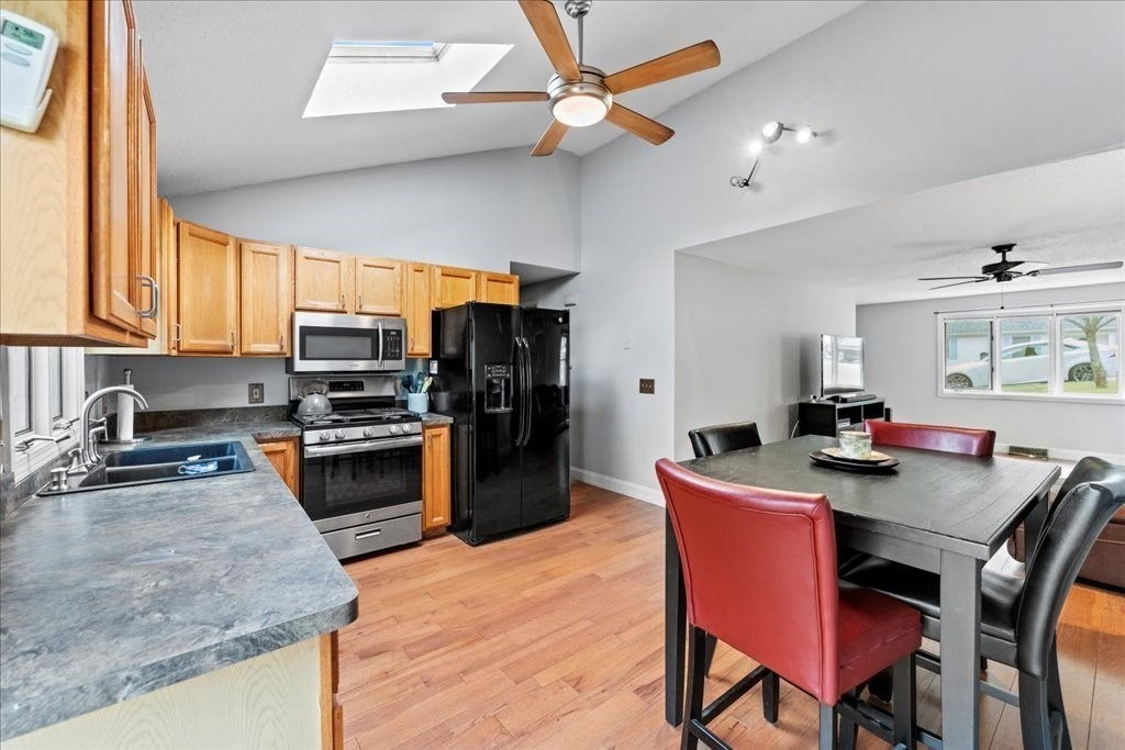 160 University Street Springfield, MA 01104 - Photo 6 of 30 a kitchen with stainless steel appliances granite countertop a kitchen island hardwood floor sink stove dining table and chairs