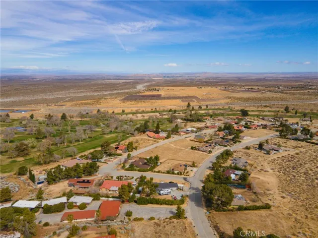 an aerial view of ocean and residential houses with outdoor space