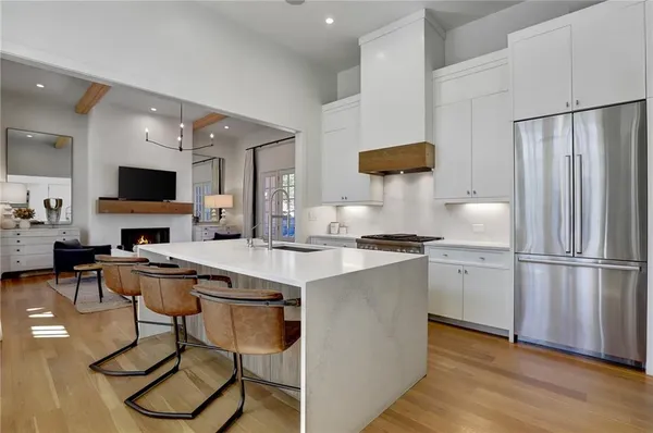 a kitchen with stainless steel appliances a stove a sink refrigerator and a fireplace