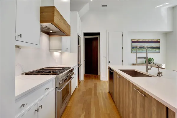 a kitchen with stainless steel appliances granite countertop a sink and a stove