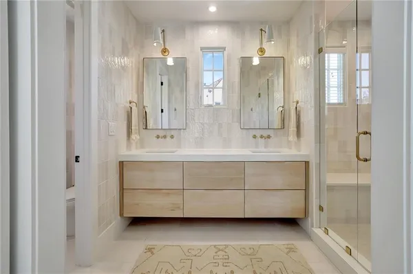 a bathroom with a double vanity sink mirror and shower