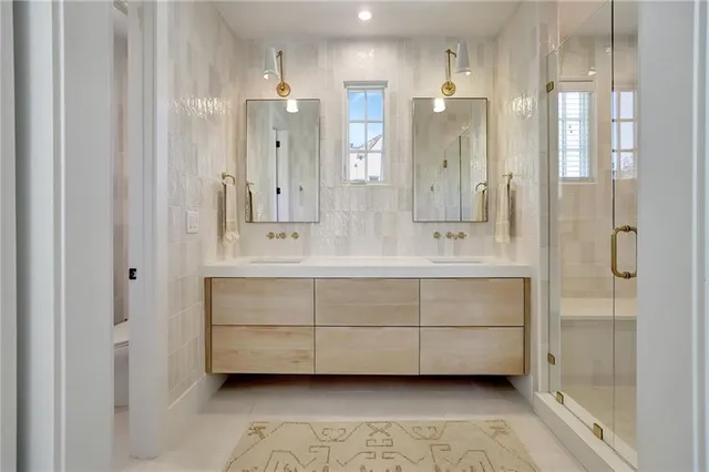 a bathroom with a double vanity sink mirror and shower