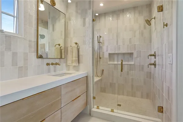 a bathroom with a shower sink vanity and mirror