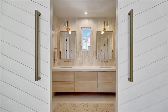 a bathroom with a double vanity sink a mirror and shower