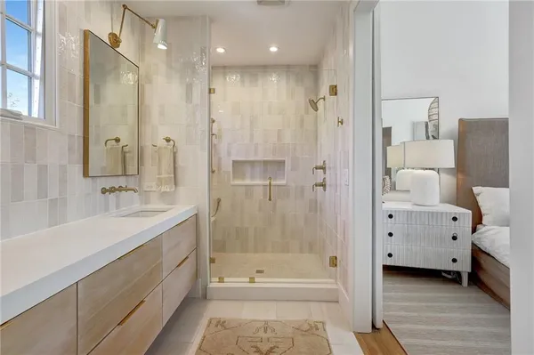 a bathroom with a tub shower sink and mirror