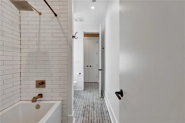 a bathroom with a tub shower sink and toilet
